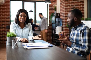 Genç siyahi kadın iş deneyimlerini ve beklentilerini profesyonel işe alma müdürüne anlatıyor. Erkek oyuncu ve kadın aday modern bir ofiste resmi bir tartışmaya giriştiler..