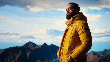 Gururlu mutlu kâşif dağ zirvesine tırmanmaktan memnun, farkındalığın ve kararlılığın tadını çıkarıyor. Genç yetişkin vahşi doğa ve destansı manzara hakkında tutkulu oluyor. Kamera A.