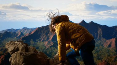 Sakar yürüyüşçü, dikkatsizlikten dolayı bir dağ tepesinden düşüp tökezleyerek bir kazaya yol açtı. Düşüncesiz hazırlıksız gezgin dengesiz arazide tökezliyor. Kamera B.