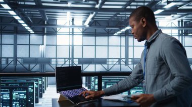 Bilgisayar ve tablet entegre yapay zeka otomasyon araçlarıyla veri merkezinde teknisyen. Aygıtlar üzerinde yapay zeka kullanan sunucu odası çalışanı, sürekli güncelleme sağlıyor, kamera B