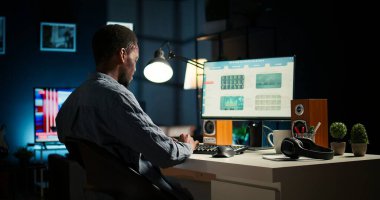 Afrika kökenli Amerikalı yatırım uzmanı evde mali istatistikleri analiz ederek büyüme için küresel bir yatırım çözümü geliştiriyor. Ekonomi danışmanı gelir beyannamesini inceliyor. Kamera A.