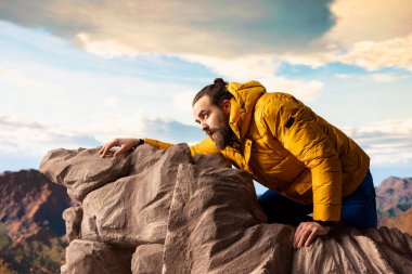 Yürüyüşçü dağın zirvesini hafife alıyor ve tepede bitkin düşüyor, kayalara basıp kayıyor ve hayatını riske atıyor. Hazırlıksız genç dağcı dengesini kaybediyor.