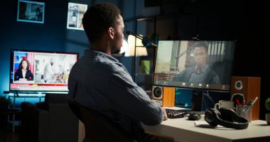 Siyah işçi lideriyle video konferans görüşmesi yoluyla görüşüyor, ev ofisinden görevlerini ve görüşlerini paylaşıyor. Genç yetişkin, patronla internet sohbetine katılıyor. Kamera A.