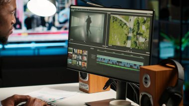 Erkek video düzenleyici, renk düzeltmesi kullanarak ve görsel efektler ekleyerek kurgu yaratmak için yaratıcı yazılım üzerinde çalışıyor. İçerik yaratıcısı grafikleri düzenliyor ve film sonrası prodüksiyon gradyanı. Kamera B