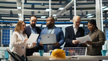 Yönetim yöneticileri güneş paneli üretimi için otomasyon stratejileri hakkında konuşuyor. Fabrikadaki işadamları çevre dostu enerji üretim sektöründe finansal yatırımlar yapıyorlar, kamera B