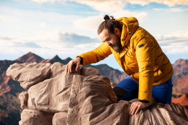 Tecrübesiz, yorgun bir yürüyüşçü aşırı koşullarda dengesini kaybeder ve düşerken dengesini korumaya çalışır. Uzak vahşi doğa güzellik sunuyor ama aynı zamanda ölümcül riskler ve pervasızlıklar da sunuyor..