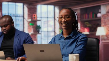 Afrika kökenli Amerikalı bir kadın partneriyle görevleri çözmek için not defterinde raporları kontrol ediyor, evlerinin rahatlığından bağımsız işler yapıyor. Bilgisayarla araştırma yapan odaklanmış insanlar. Kamera B.