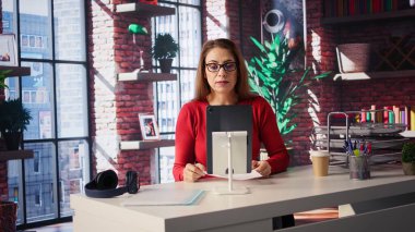 Eğitmeniyle yaptığı sanal görüşmede gülümseyen uzaktan kumandalı kadın internet araçları ve internet bağlantılarının etkinliğini gösteriyor. Yeni iş için eğitime başlayan bir kadın. Kamera B.