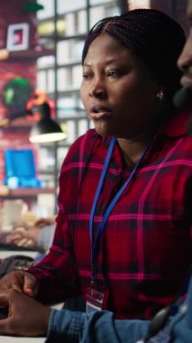 Ofisteki dikey video çağrı merkezi çalışanları müşterilere yapay zeka kullanarak hesaplara erişmelerine yardım ediyor, şifreleri sıfırlıyorlar. Müşteri merkezindeki meslektaşlar, yapay yardım ihtiyacı olan müşterilere yardım ediyor.