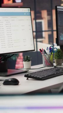 Boş ofiste analitik gösterge panelleri ve veri grafiklerini gösteren dikey video ekranları. Dijital veri görselleştirmesini ve işletim yönetimini gösteren ekranları olan ofis çalışma alanı, el kamerası