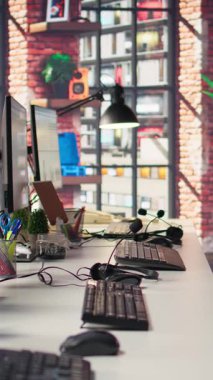 Boş ofiste analitik gösterge panelleri ve veri grafiklerini gösteren dikey video ekranları. Dijital veri görselleştirmesini ve işletim yönetimini gösteren ekranları olan ofis çalışma alanı, el kamerası