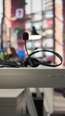 İşçiler tarafından müşterilerle konuşmak için kullanılan çağrı merkezi masasında mikrofon bulunan dikey video kulaklıklar. Müşterilerle konuşmak için müşteri destekli iş yerinde kullanılan mikrofon kulaklığı, kapat