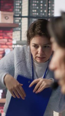 Dikey video ekip lideri çağrı merkezi ajanının ofisindeki sevkiyatları izlemesini denetliyor. Müşteri merkezi yöneticisi, hasta paketlerinin yerini belirleyen ve durum güncellemeleri sağlayan çalışanları denetliyor