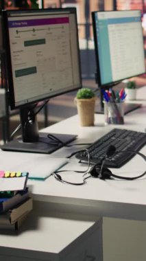Boş müşteri hizmetleri işyerindeki bilgisayar monitörlerindeki dikey video CSM sistem arayüzleri ve çağrı merkezi ses kulaklıkları. PC görüntüleme ve kulaklıklarda müşteri hizmetleri yönetimi yazılımı UI