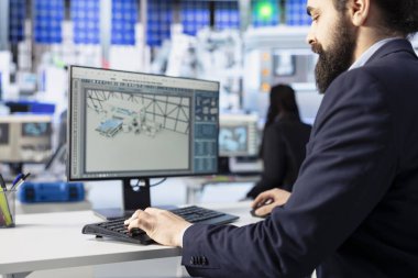Photovoltaics tesis çalışanı bilgisayardaki verimlilik raporlarını inceliyor, üretim üretimini artırmak için eğilimleri yorumluyor. Güneş panellerinin kapatılması potansiyel sistem arızalarını tespit eden bitki uzmanları