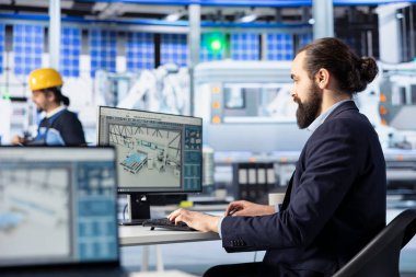 Fotovoltaik fabrikası mühendisi güneş modülleri için CAD modelleri ve teknik çizimler yapıyor. Çalışan verimlilik ve üretim için güneş paneli tasarımları geliştiriyor ve optimize ediyor