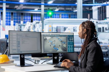 Yazılım geliştiricisi fotovoltaik üretim tesisinde PC 'de kod yazıyor, yazılım araçları geliştiriyor. Sistem yöneticisi sistem verimliliğini arttırmak için bilgisayarda otomasyon rutinleri geliştiriyor