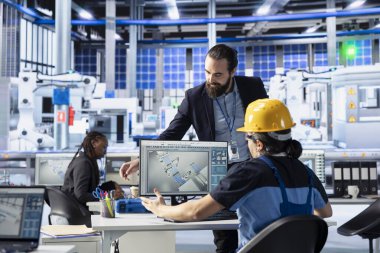 Sanayi otomasyon uzmanları yüksek teknoloji güneş paneli fabrikasında yazılım arayüzü üzerinden robot makine ayarlarını ayarlıyorlar. Fotovoltaik fabrikası uzmanları ekipman performans sorunlarını teşhis ediyorlar