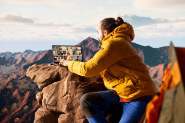 İnternet üzerinden iş arkadaşlarıyla buluşan işkolik kaşifler, dağın tepesinde yüksek hızlı bir internet sinyalinin keyfini çıkarıyorlar. İş bağımlılığı olan genç bir yürüyüşçü..