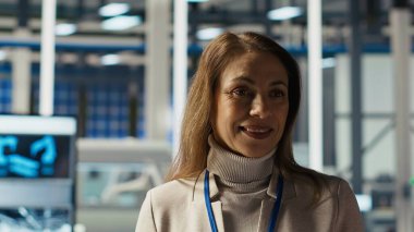 Fabrikadaki gülümseyen bilim adamının portresi PV materyal parametrelerini kontrol etmek için tablet kullanıyor, güneş panellerini geliştiriyor. Happy araştırmacı etkili sürdürülebilir enerji çözümleri geliştirmek Cihaz, kamera B kullanarak