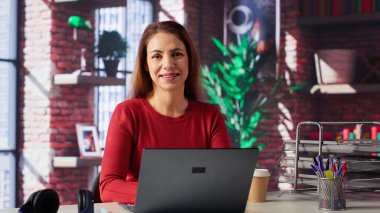 Merkez ofisteki bir iş projesi için çevrimiçi araştırma yapan, dizüstü bilgisayarda oturup internette makaleler okuyan bir kadın. Web sitelerinde sörf yapan, veri toplayan, telesekreter. Kamera A.