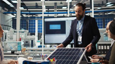Araştırma ve geliştirme ekibi enerji dönüşüm oranlarını optimize etmek için güneş pili prototiplerini analiz ediyor. Güneş panelleri yenilikçi üretim teknikleri geliştiren bitki uzmanları, kamera A