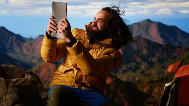 Teknolojiye bağımlı yürüyüşçü doğanın güzelliğini görmezden gelir ve rüzgarlı bir kamp alanında çalışır. Rüzgardan ve soğuk havadan korunmak için çadırına girer. Teknoloji bağımlılığının tehlikeleri. Kamera B.