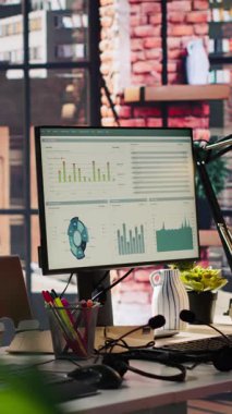 Ofis masasındaki dikey bilgisayar monitörleri veri analizlerini ve performans çizelgelerini gösteriyor. Finansal ölçümler ve üretkenlik verilerini gösteren şirket çalışma alanındaki bilgisayar ekranları