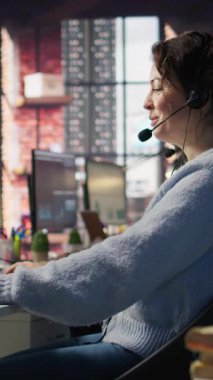 Gelen aramalarla ilgilenen dikey video çağrı merkezi ajanı, sorgulamada müşterilere yardım eden, hesap kayıtlarını güncelleyen ve ofis ortamında performans ölçümlerini karşılayan kamera B, kapat