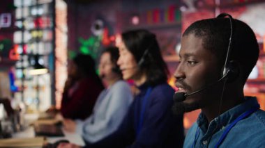 Merkezi ara. Kulaklıkla müşterilerle konuş. Hesaplara tekrar erişmene yardım et. Müşteri merkezi çalışanı mikrofonla konuşuyor. Yardıma ihtiyacı olan müşterilere yardım ediyor. Kamera B, kapat.