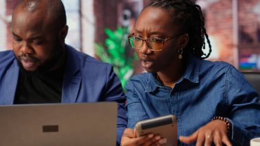 Siyahi adam ve kadın finansal belgeleri analiz ediyor ve masrafları, gelir ve tasarruf yönetimini takip ediyor. Vergi ödemeye ve ev bütçesini planlamaya hazırlanan çift. Kamera B.