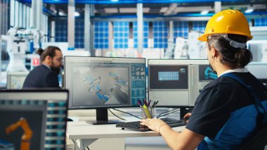 Güneş panelleri üreten fabrika teknisyeni, yerleşim planlarını optimize etmek için CAD programını kullanıyor. Fotovoltaik fabrikası çalışanı maksimum yenilenebilir enerji çıkışı için düzenleme yapıyor, kamera A