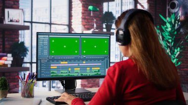 Odaklanmış editör kadın kopya alanının yanında video montajı üzerinde çalışıyor, evdeki masaüstünde yaratıcı yazılım. Film yapımcısı çekimleri düzenlemek ve içerik yaratmak için çift monitör kullanıyor. Kamera B.