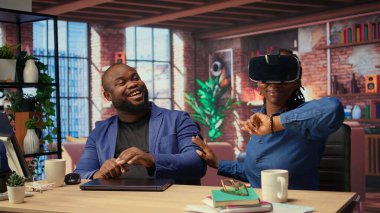 Afrika kökenli Amerikalı bir kadın sanal gerçekliği sanal gerçeklik cihazıyla keşfederken ortağı da uzaktan bilgisayarla çalışıyor. Genç çift evde yapay zekayla modern teknoloji ve aletleri kucaklıyor. Kamera A.