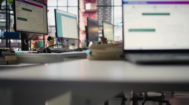 Ofis masasındaki bilgisayar monitörleri veri analizlerini ve performans çizelgelerini gösteriyor. Finansal ölçümler ve üretkenlik verilerini gösteren şirket çalışma alanındaki bilgisayar ekranları