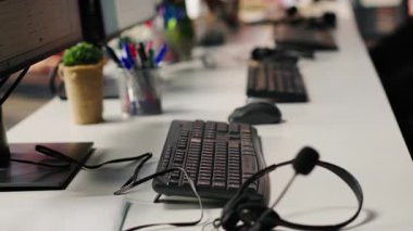 Boş müşteri hizmetleri işyerindeki bilgisayar monitörlerindeki CSM sistem arayüzleri ve çağrı merkezi ses kulaklıkları. Müşteri hizmetleri yönetimi yazılımı PC ekranlarında UI ve masasında mikrofon olan kulaklıklar