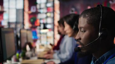 Destek veren merkezi ara, müşterileri şikâyet et, mikrofonla konuş. Çalışan memnuniyetsiz müşterilerle ilgileniyor, kulaklık mikrofonuyla konuşuyor, kamera B aşırı yakın plan.