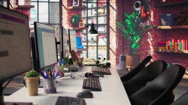 PC boş ofiste analitik gösterge panelleri ve veri grafiklerini gösterir. Dijital veri görselleştirmesini ve işletim yönetimini gösteren ekranları olan ofis çalışma alanı, el kamerası görüntüsü