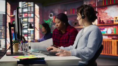 Çağrı merkezi lideri, bilgisayar masasındaki meslektaşının yanındaki evrakları inceliyor. Müşteri destek müdürü, B kamerasında stajyer doktorlara şirket belgelerini açıklıyor.