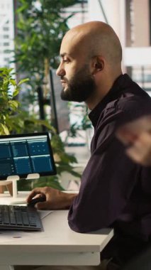 Dikey video Arap ofis memuru gelir, kazanç ve operasyonel verimlilik için kilit performans hedeflerini vurmaya çalışıyor. Orta Doğulu bir çalışan araştırma analizi yapıyor. Kamera A.