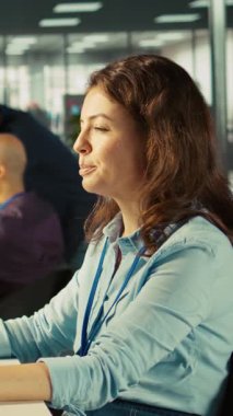 Ofis masasında çalışan dikey video çalışanı klavyeye yazı yazıyor, bilgisayardaki belgeleri düzenliyor. İşçi PC 'nin iş yerindeki hesap tablolarına veri giriyor, istatistiksel bilgiler üzerinde çalışıyor, kamera B