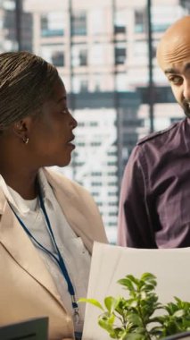 Görevdeki dikey video çalışanları son teslim tarihinden önce projeyi bitirmek için birlikte çalışıyorlar, beyin fırtınası yapıyorlar. Takım çalışanı iş arkadaşları görevler, kamera A üzerinde işbirliği yapıyorlar.