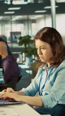 Raporları kontrol ettikten sonra finansal rakamları PC 'ye itham eden modern kurumun dikey video muhasebecisi. Modern ofiste çalışan odaklanmış iş kadını, çapraz veriler, kamera B
