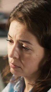 Ofisteki dikey video işçisi iş performans ölçümlerini incelerken bilgisayar masasında uyuyakalıyor. Yorgun bir kadın iş yerindeki mali tablolara bakarken uyukluyor. Kamera A.