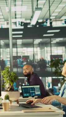 Dikey videolu Happy çalışanı yeni işindeki ilk günden başlıyor. Eşyaları yerleştiriyor, iş arkadaşlarıyla görüşüyor. Neşeli işçi ofise geliyor, yeni şirket pozisyonu üzerinde çalışmaya başlıyor, takım tarafından karşılanıyor.