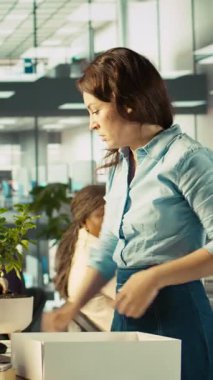 Ofisteki dikey video çalışanı işten ayrıldıktan sonra masa başı bitkilerini paketliyor ve meslektaşına veda ediyor. İşten çıkarmalar sırasında işten çıkarılan çalışanlar, üzgün iş arkadaşları, kamera B