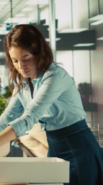 Dikey video çalışanı işten atıldıktan sonra meslektaşları tarafından teselli ediliyor. İşçi locası masa bitkileriyle dolu. İşten çıkarıldıktan sonra iş arkadaşlarına veda ediyorlar. Kamera B.