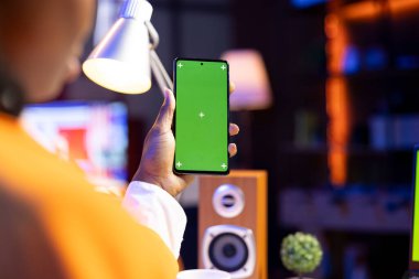 Genç, yeşil ekran model cep telefonundan mesajlar okuyor, yakın çekim. Neon ışıklı bir dairede yaşayan bir kadın izole ekran krom tuşlu bir telefondan SMS okuyor ve arkadaşlarıyla sohbet ediyor.
