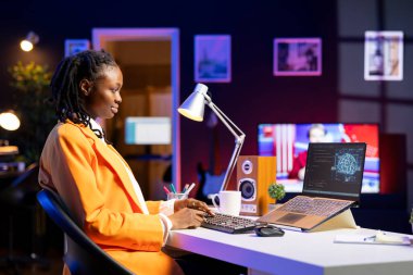 Serbest çalışan bilgisayar mühendisi yapay zeka sistemlerinin bakımını yapıyor. Uzaktan kumanda teknisyeni evden çalışıyor. Laptop kullanarak yapay zeka sistemlerini kontrol ediyor.