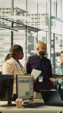 Dikey videoda gülümseyen meslektaşlar iş başarısı için heyecanlı, birbirlerini tebrik ediyorlar. Ofisteki neşeli iş arkadaşları başarıyı kutluyor, heyecanlarını dile getiriyor, beşlik çakıyor.